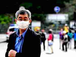 Giapponese che indossa mascherina chirurgica nelle vie della città inquinata
