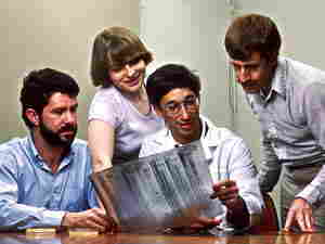 quattro scienziati al lavoro sull'elettroforesi del DNA nei laboatori NCI nel 1987